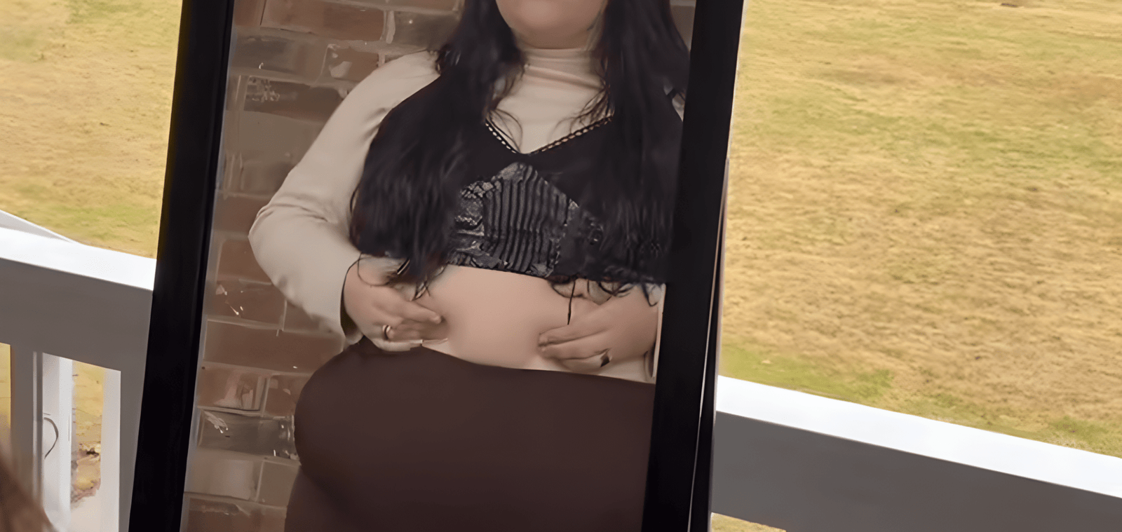 Woman noticing menopause belly in mirror